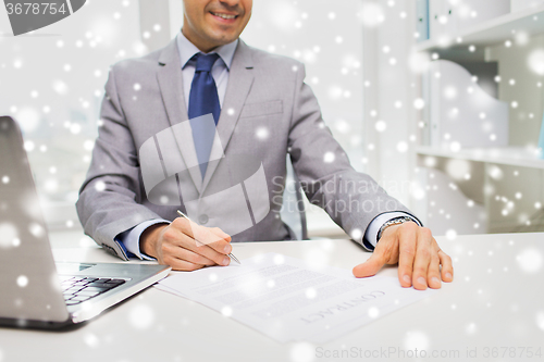 Image of close up of businessman with laptop and papers