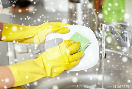 Image of close up of woman hands washing dishes in kitchen