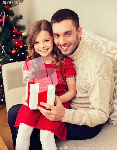 Image of smiling father and daughter holding gift box