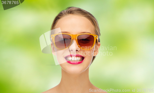 Image of happy young woman in sunglasses with pink lipstick