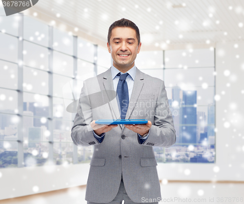 Image of happy businessman in suit holding tablet pc