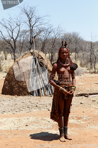 Image of Himba woman with ornaments on the neck in the village