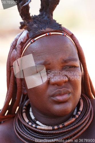 Image of Himba woman with ornaments on the neck in the village