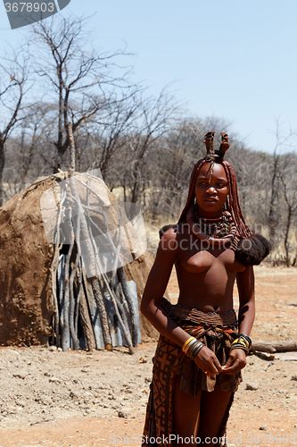 Image of Himba woman with ornaments on the neck in the village
