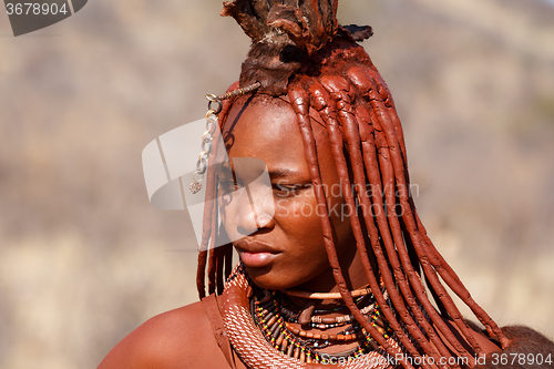 Image of Himba woman with ornaments on the neck in the village