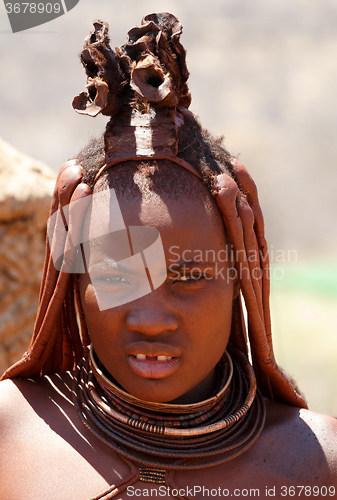 Image of Himba woman with ornaments on the neck in the village