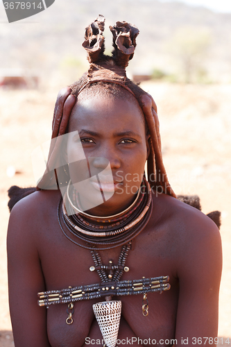 Image of Himba woman with ornaments on the neck in the village