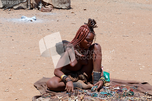 Image of Himba girl with souvenirs for sale in traditional village