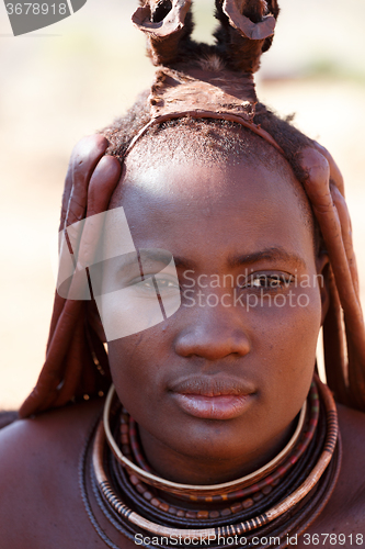 Image of Himba woman with ornaments on the neck in the village