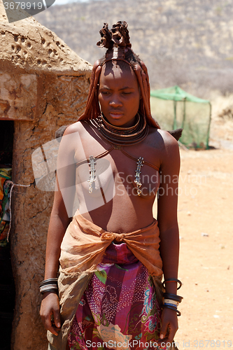 Image of Himba woman with ornaments on the neck in the village