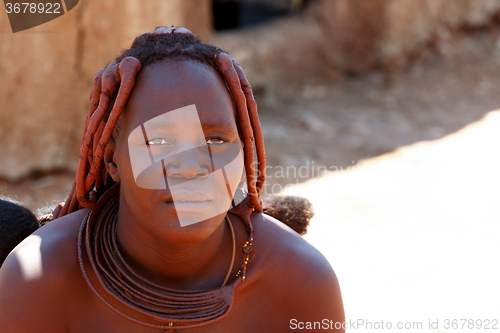 Image of Himba woman with ornaments on the neck in the village