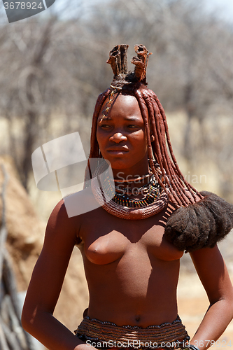 Image of Himba woman with ornaments on the neck in the village