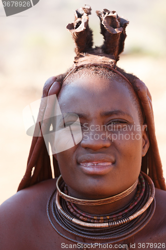 Image of Himba woman with ornaments on the neck in the village