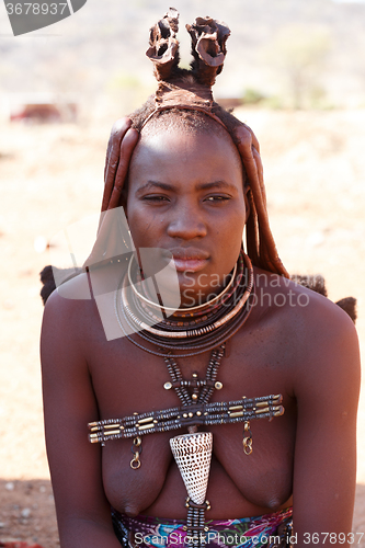 Image of Himba woman with ornaments on the neck in the village