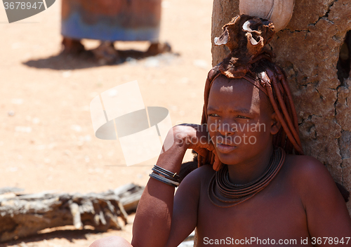 Image of Himba woman with ornaments on the neck in the village