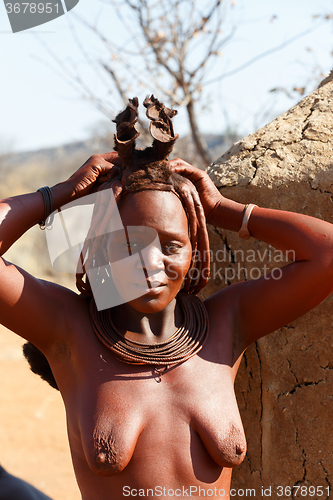 Image of Himba woman with ornaments on the neck in the village