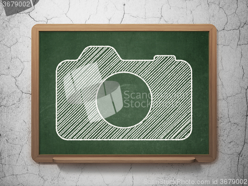 Image of Travel concept: Photo Camera on chalkboard background