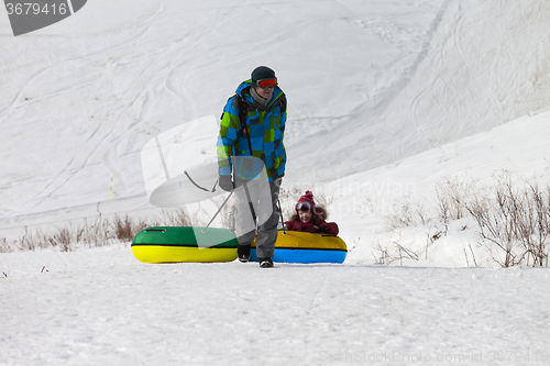 Image of Father and daughter with snow tube