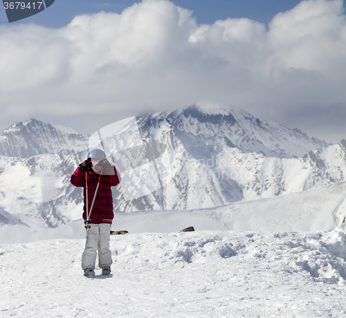 Image of Little skier on top of ski slope at sun day