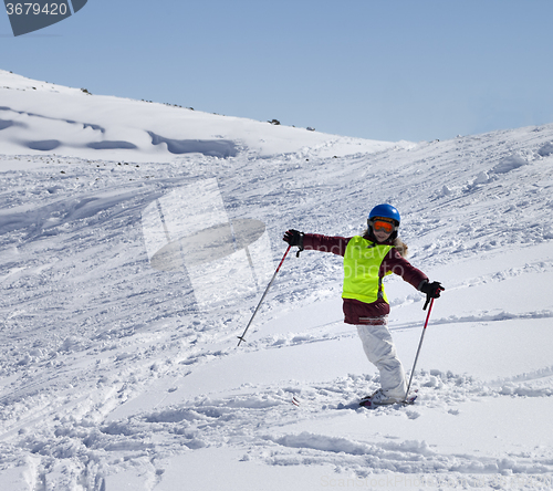 Image of Little skier on ski slope with new fallen snow at sun day