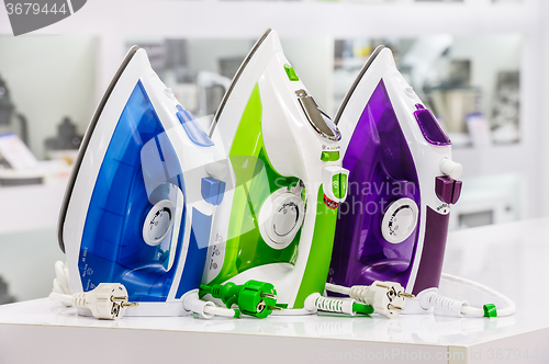 Image of three electric irons in retail store