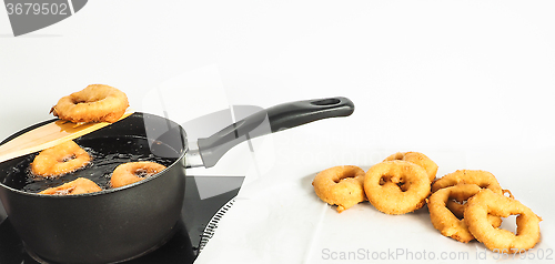 Image of Fresh made doughnuts from boiling hot oil onto baking paper