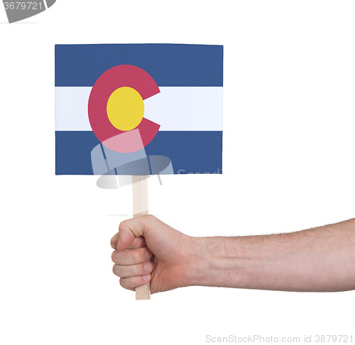 Image of Hand holding small card - Flag of Colorado