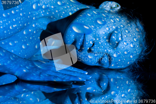 Image of The  body of woman with blue pattern and its reflection