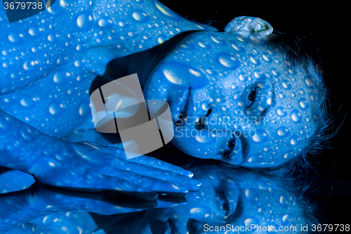 Image of The  body of woman with blue pattern and its reflection