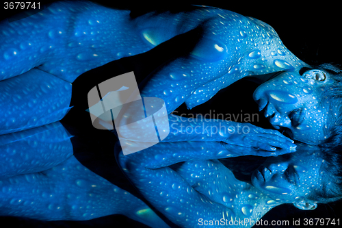 Image of The  body of woman with blue pattern and its reflection