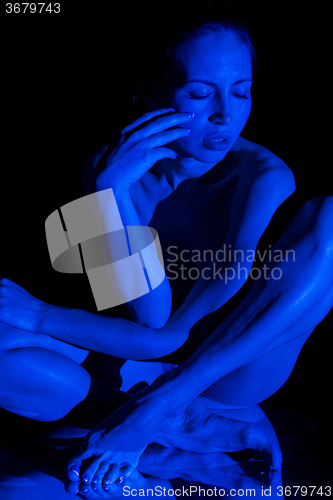 Image of The  body of woman in the blue beam projector