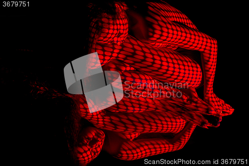 Image of The  body of woman with red pattern and its reflection