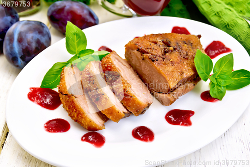 Image of Duck breast with plum sauce and basil on plate