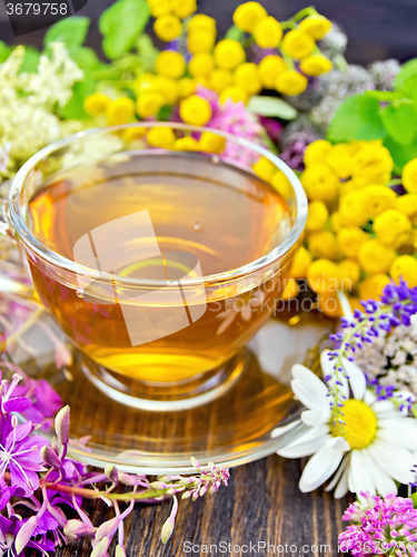 Image of Tea from wild flowers in glass cup on board