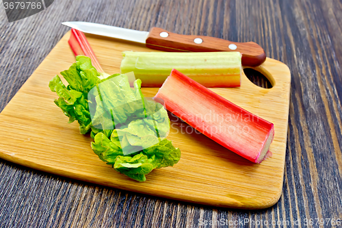 Image of Rhubarb with knife and leaf on dark board