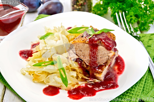 Image of Duck breast with plum sauce and cabbage in plate