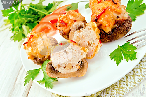 Image of Champignons stuffed meat cut in white plate on board