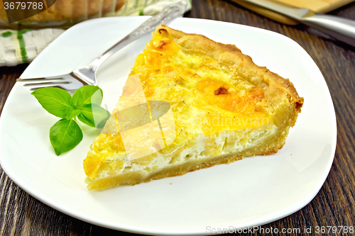 Image of Pie with cheese and leeks in plate on board