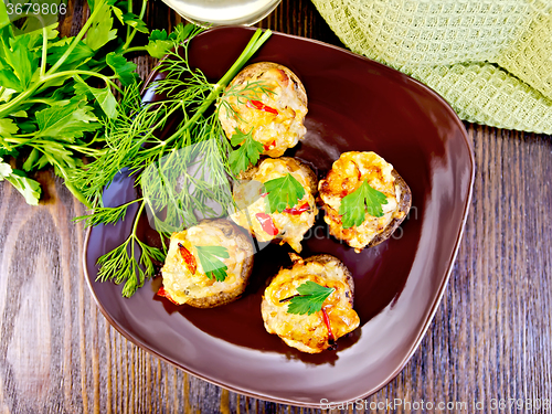 Image of Champignons stuffed meat in brown plate on board top