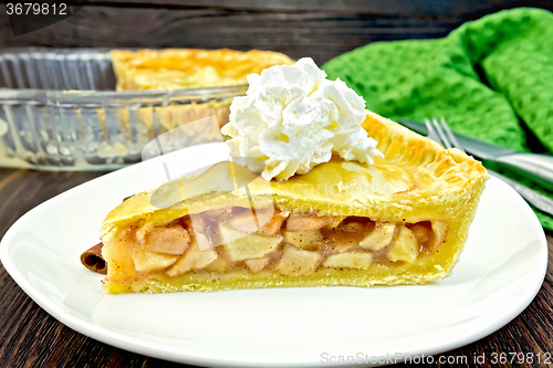 Image of Pie apple with whipped cream in plate on board