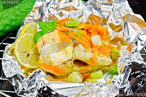 Image of Pike with carrots and leeks in foil on board