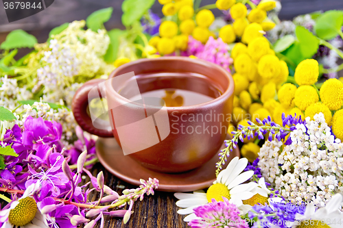 Image of Tea from flowers in clay cup on dark board