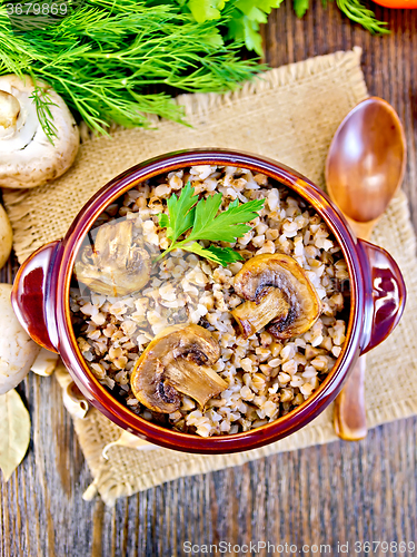 Image of Buckwheat with champignons in clay bowl on table top