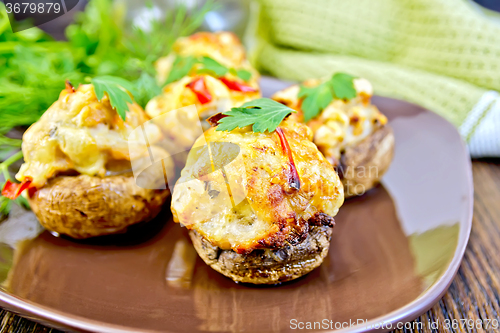 Image of Champignons stuffed meat with parsley in brown plate on board