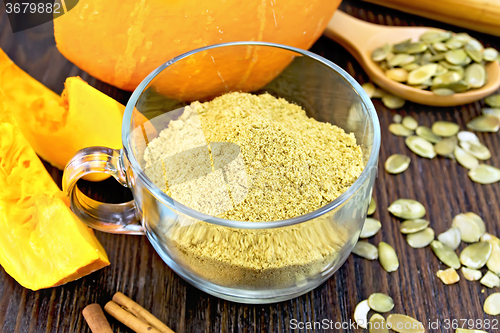 Image of Flour pumpkin in glass cup with seeds and cinnamon on board