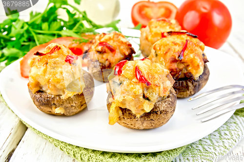 Image of Champignons stuffed meat in white plate on light board