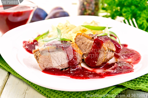 Image of Duck breast with plum sauce and cabbage in plate