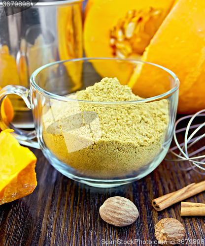 Image of Flour pumpkin in glass cup with sieve and cinnamon on board