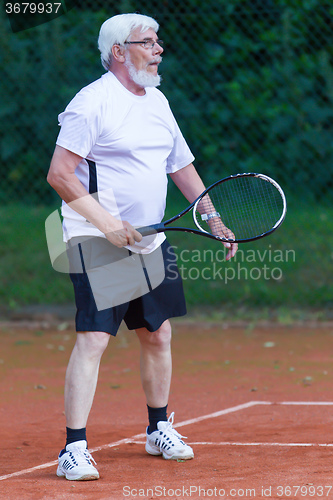 Image of Senior man playing tennis