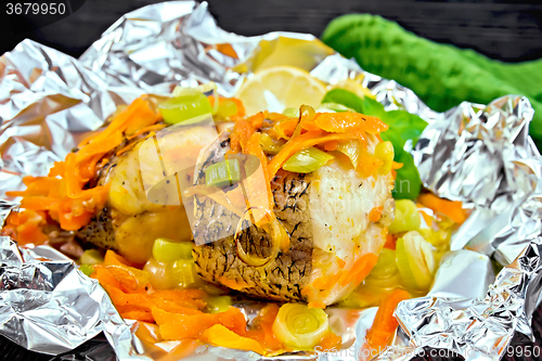 Image of Pike with carrots and onions in foil on board